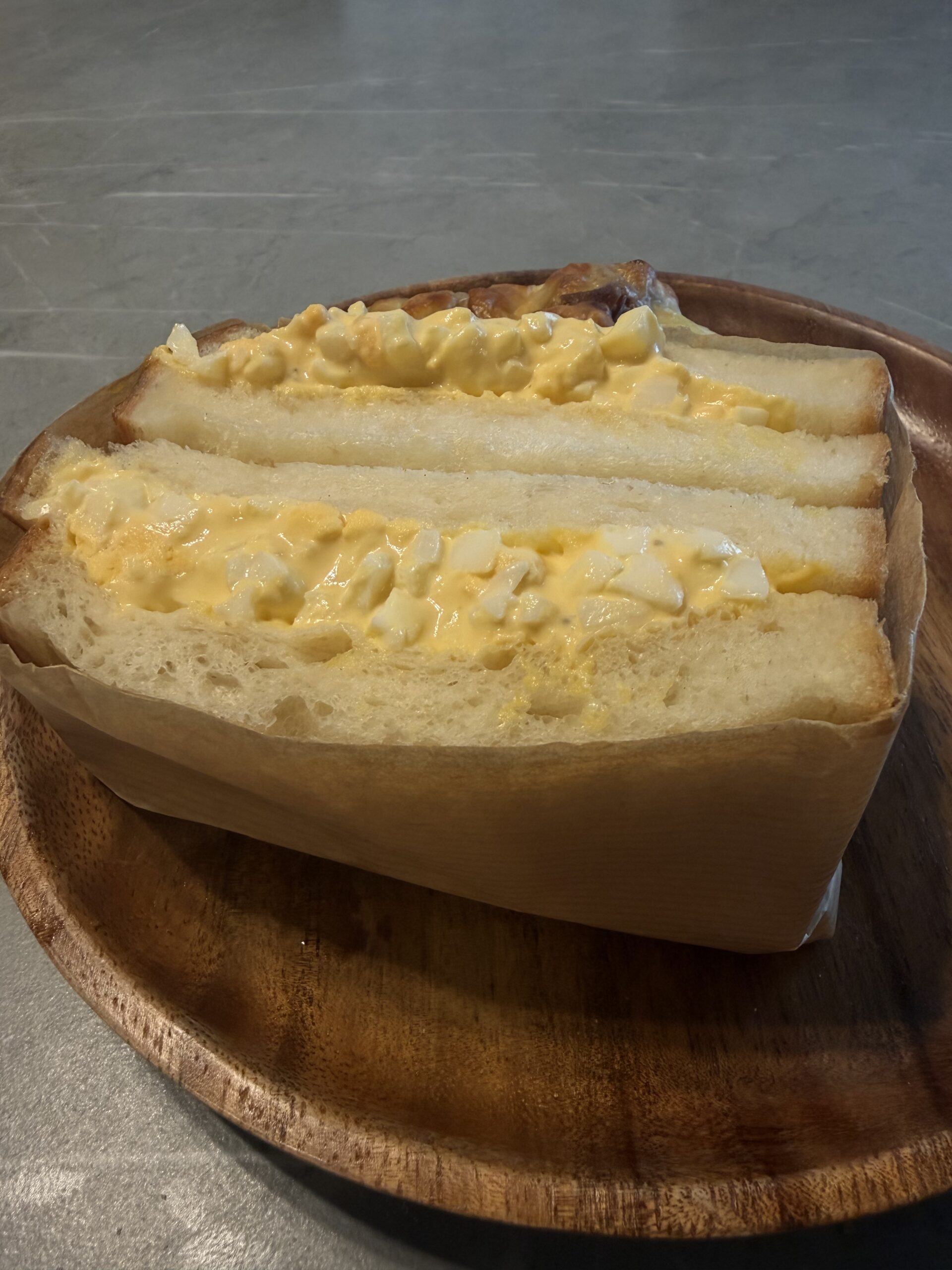 木のお皿に盛り付けたadessoのたまごサンド