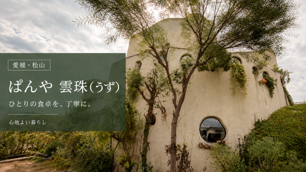 緑に囲まれた「ぱんや 雲珠(うず)」の外観。「ひとりの食卓を、丁寧に。」の文字入り