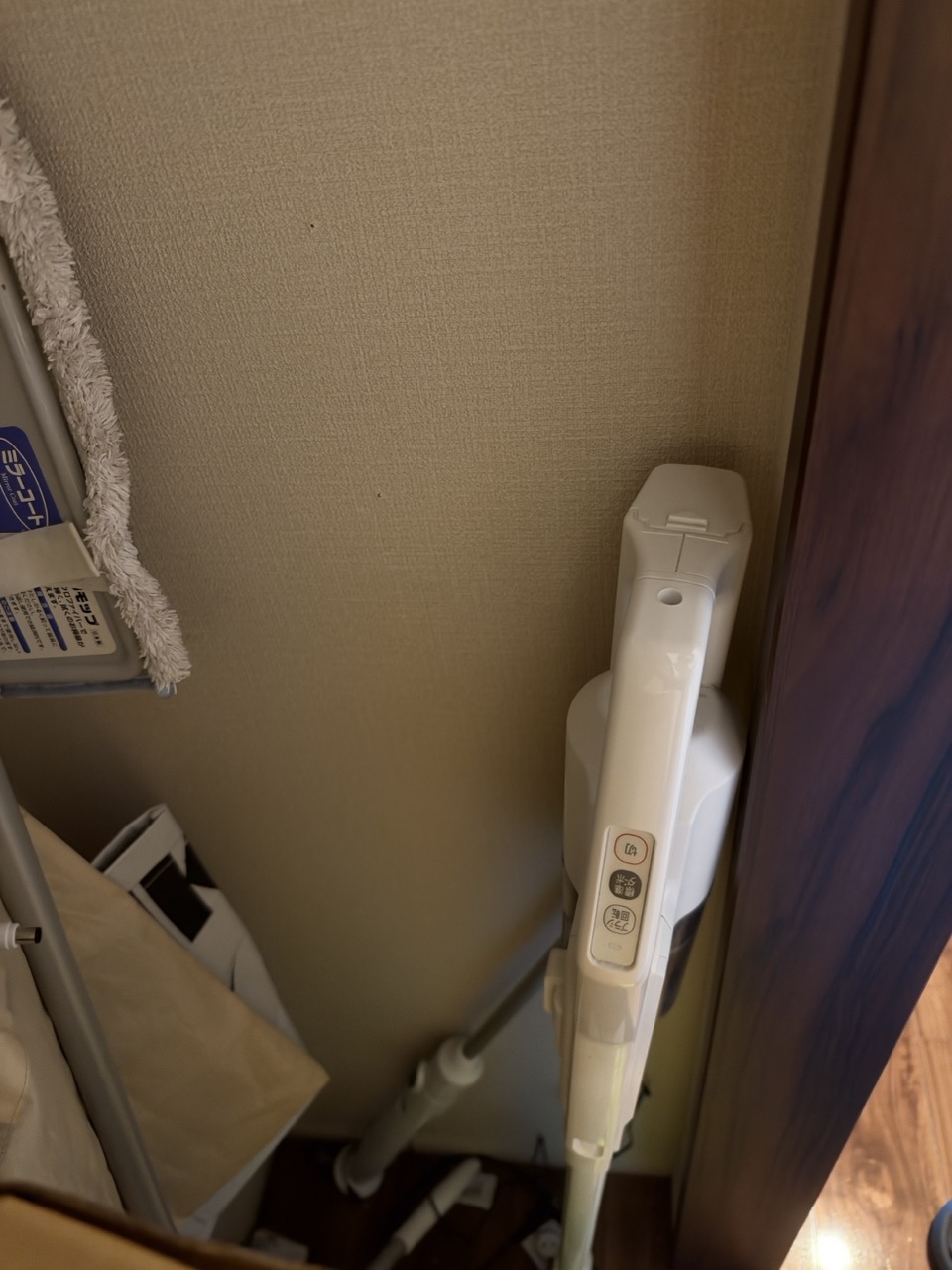 収納内の壁際に置いた掃除機と、隣にある掃除道具